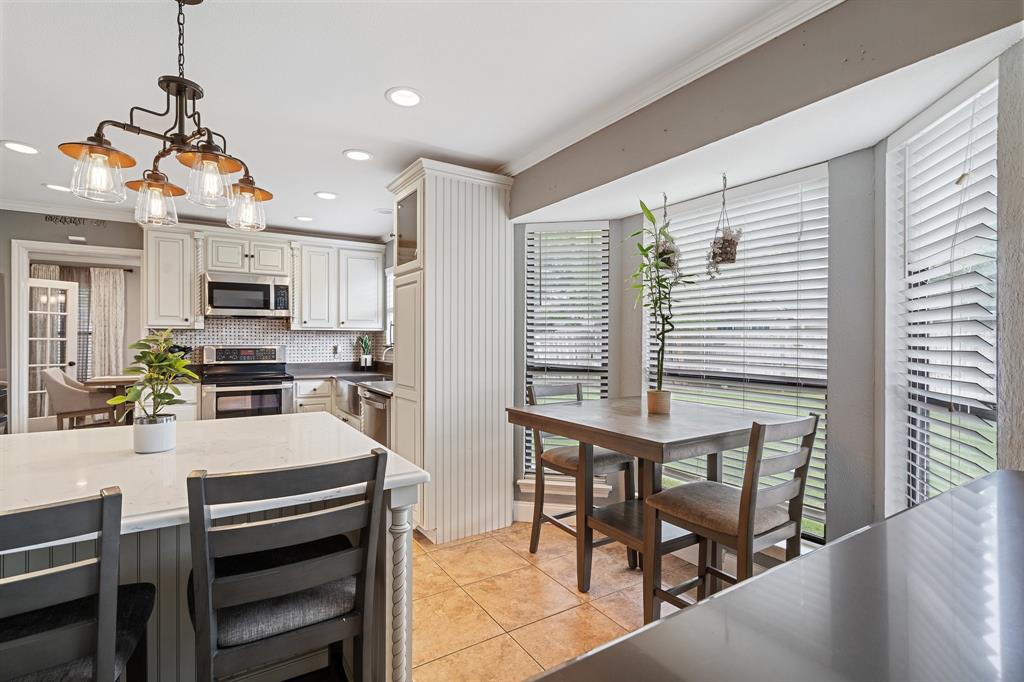 303 Hopewell Street Grand Prairie, TX 75052 - Photo 10 of 28 a kitchen with a table chairs microwave and cabinets