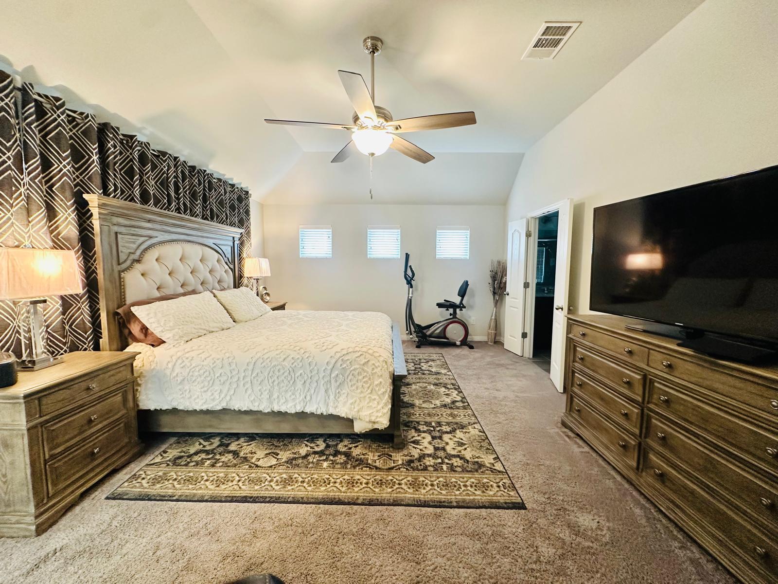 862 Leadtree Loop Buda, TX 78610 - Photo 22 of 40 a spacious bedroom with a bed and a flat screen tv