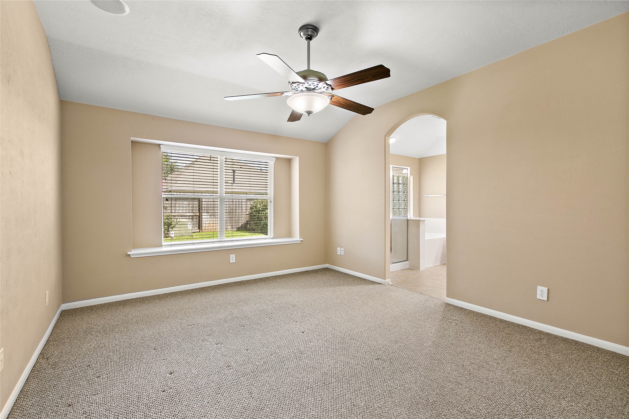 30411 Deleon Fields Drive Spring, TX 77386 - Photo 14 of 24 Relax in this bright bedroom featuring high ceilings, a large window, and direct access to the private bath.