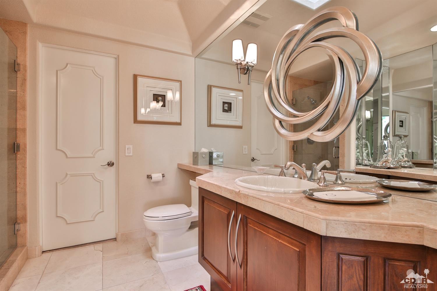 70689 Boothill Road Rancho Mirage, CA 92270 - Photo 11 of 45 a bathroom with a granite countertop toilet a sink and a mirror