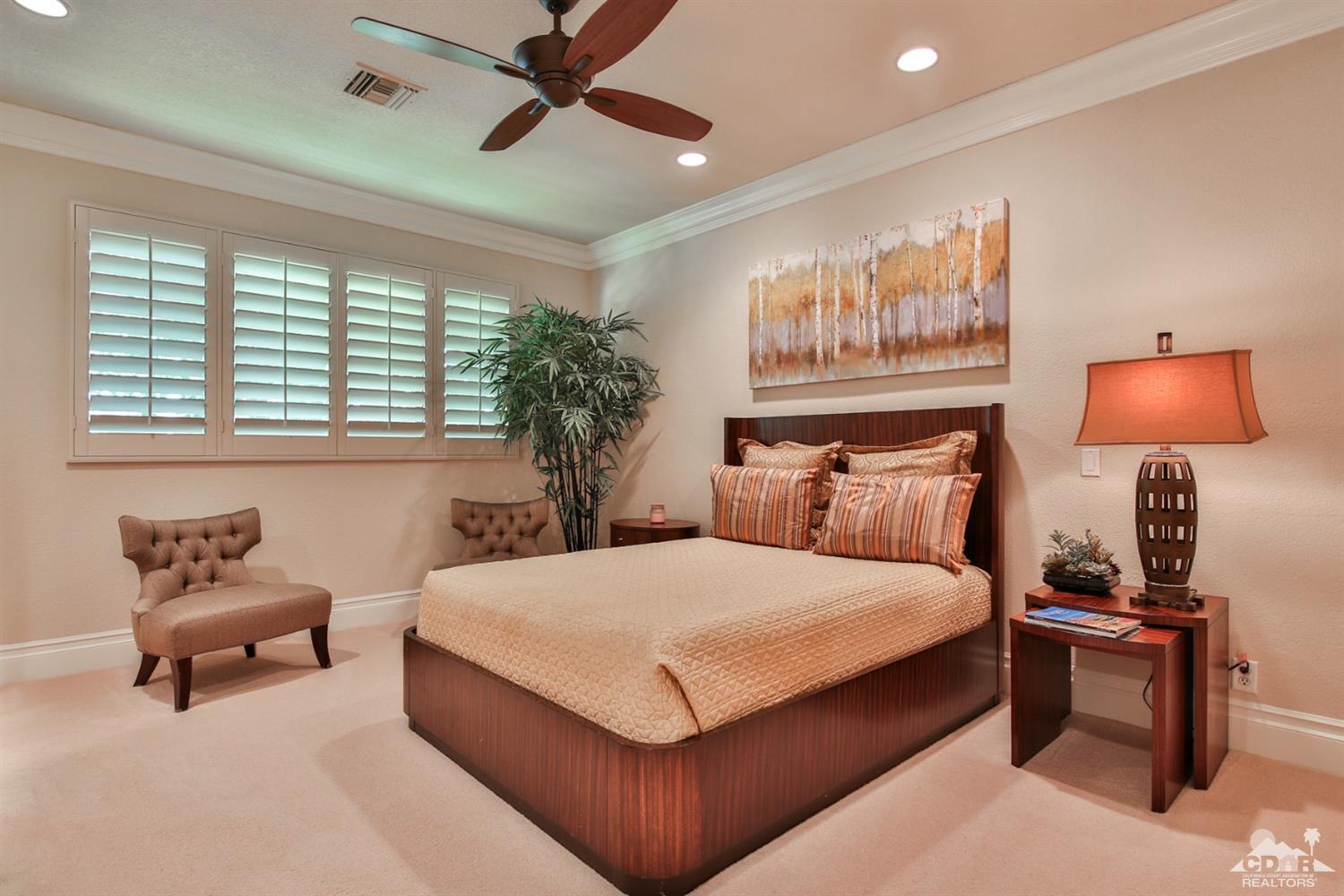 70689 Boothill Road Rancho Mirage, CA 92270 - Photo 25 of 45 a bedroom with a bed and a chandelier
