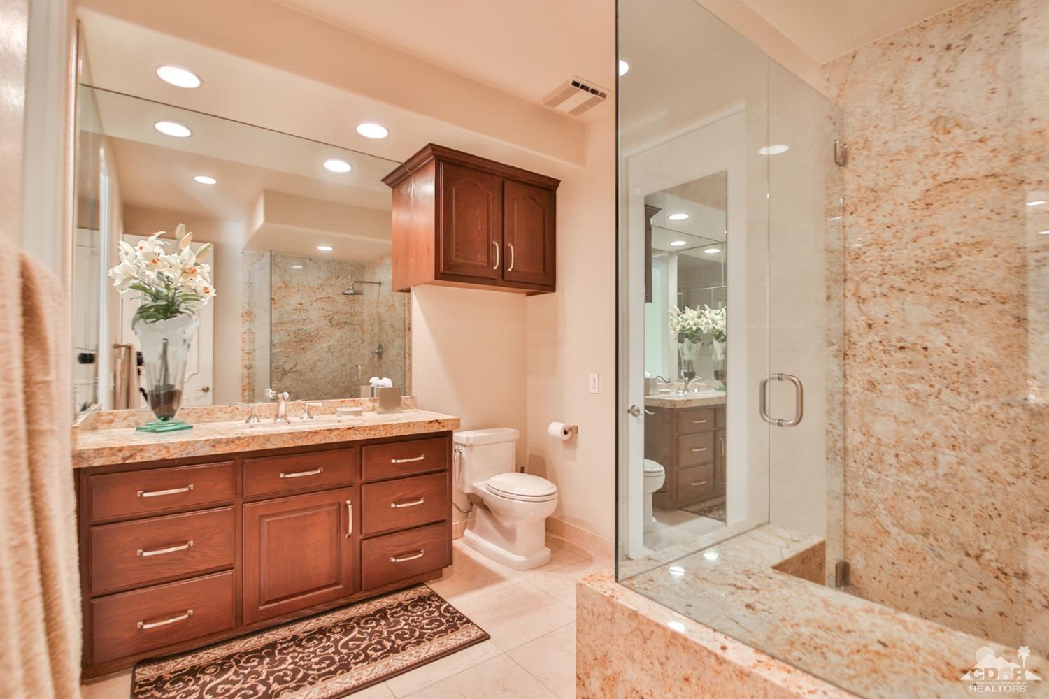 70689 Boothill Road Rancho Mirage, CA 92270 - Photo 30 of 45 a spacious bathroom with a granite countertop sink a toilet a mirror and shower
