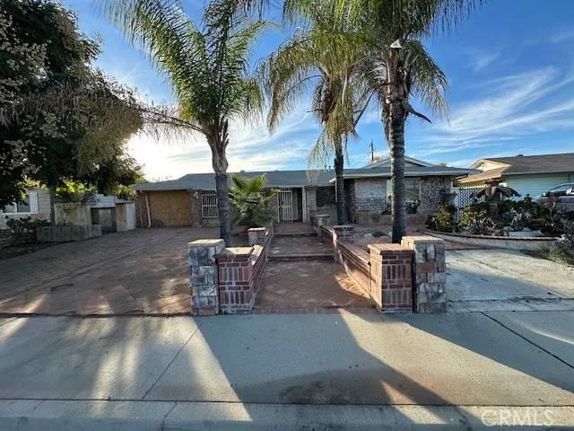 a view of a patio with table and chairs potted plants and palm trees