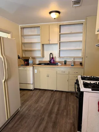 a kitchen with a sink a refrigerator and cabinets