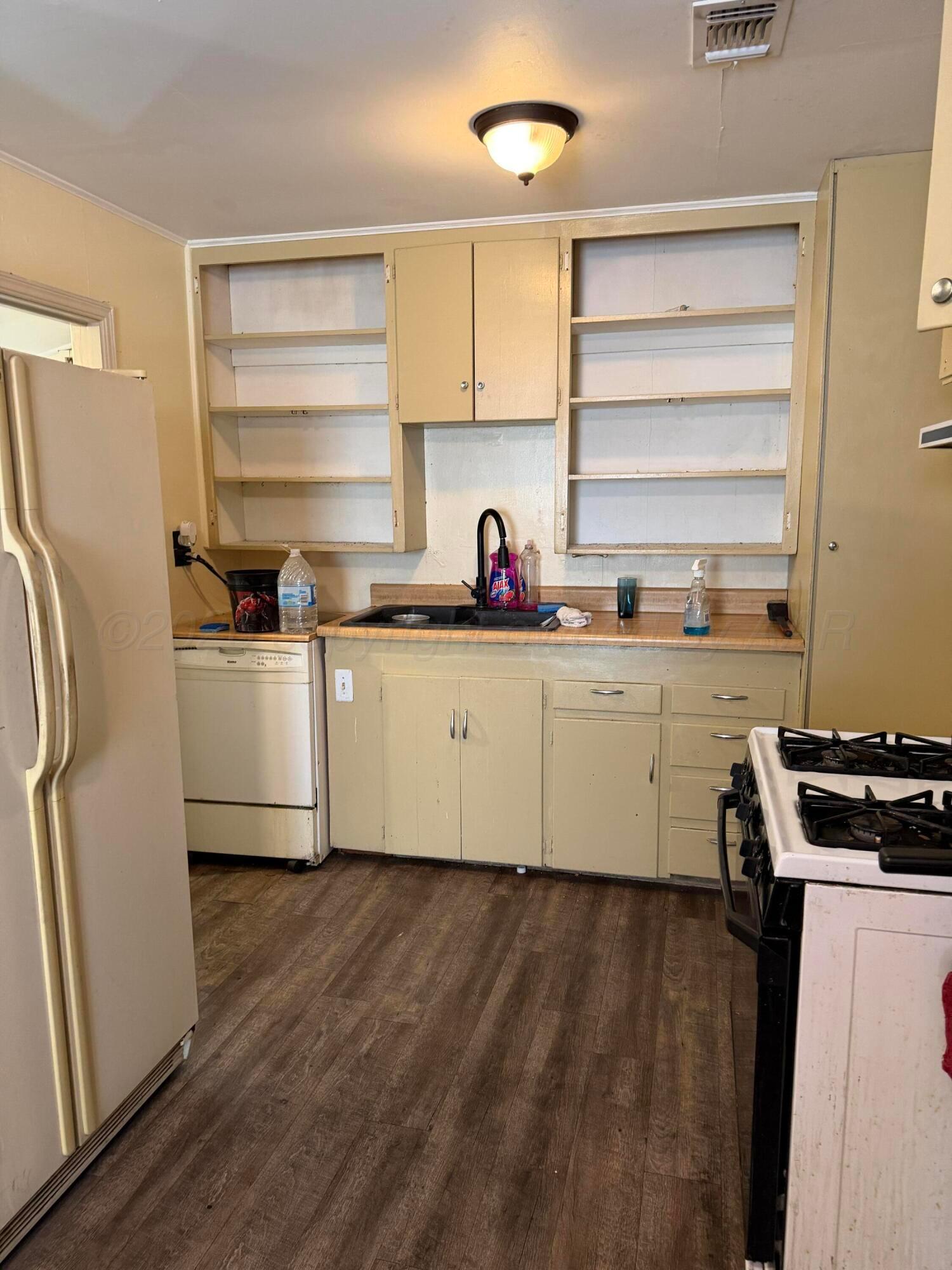 215 Hickory Street Borger, TX 79007 - Photo 10 of 18 a kitchen with a sink a refrigerator and cabinets