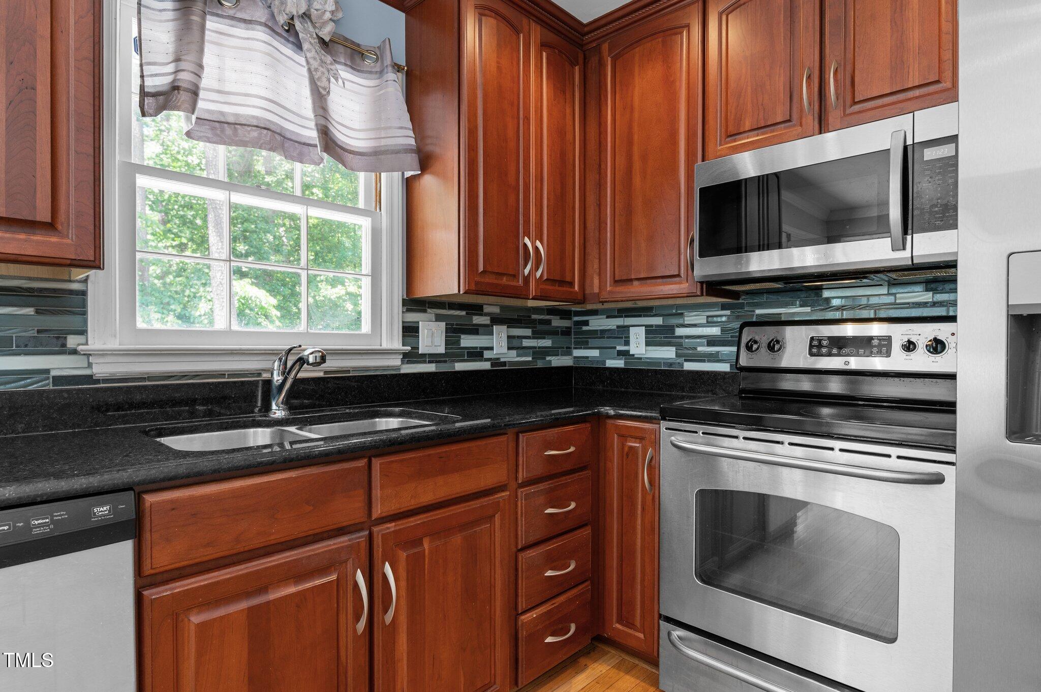 612 Harvest Lane Raleigh, NC 27606 - Photo 11 of 38 a kitchen with granite countertop a sink and a stove top oven