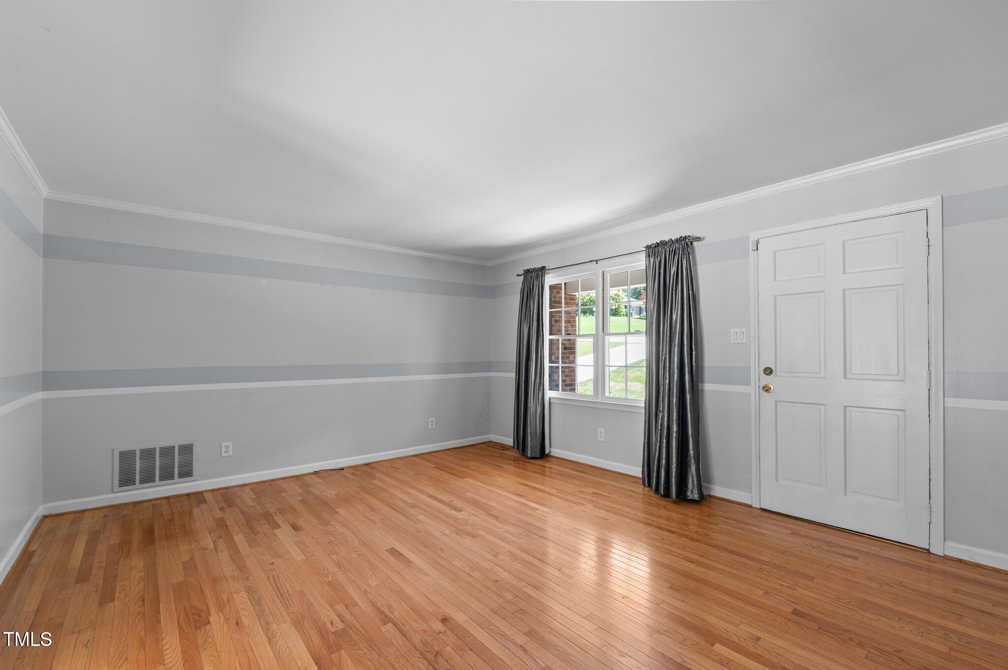 612 Harvest Lane Raleigh, NC 27606 - Photo 7 of 38 wooden floor in an empty room with a window
