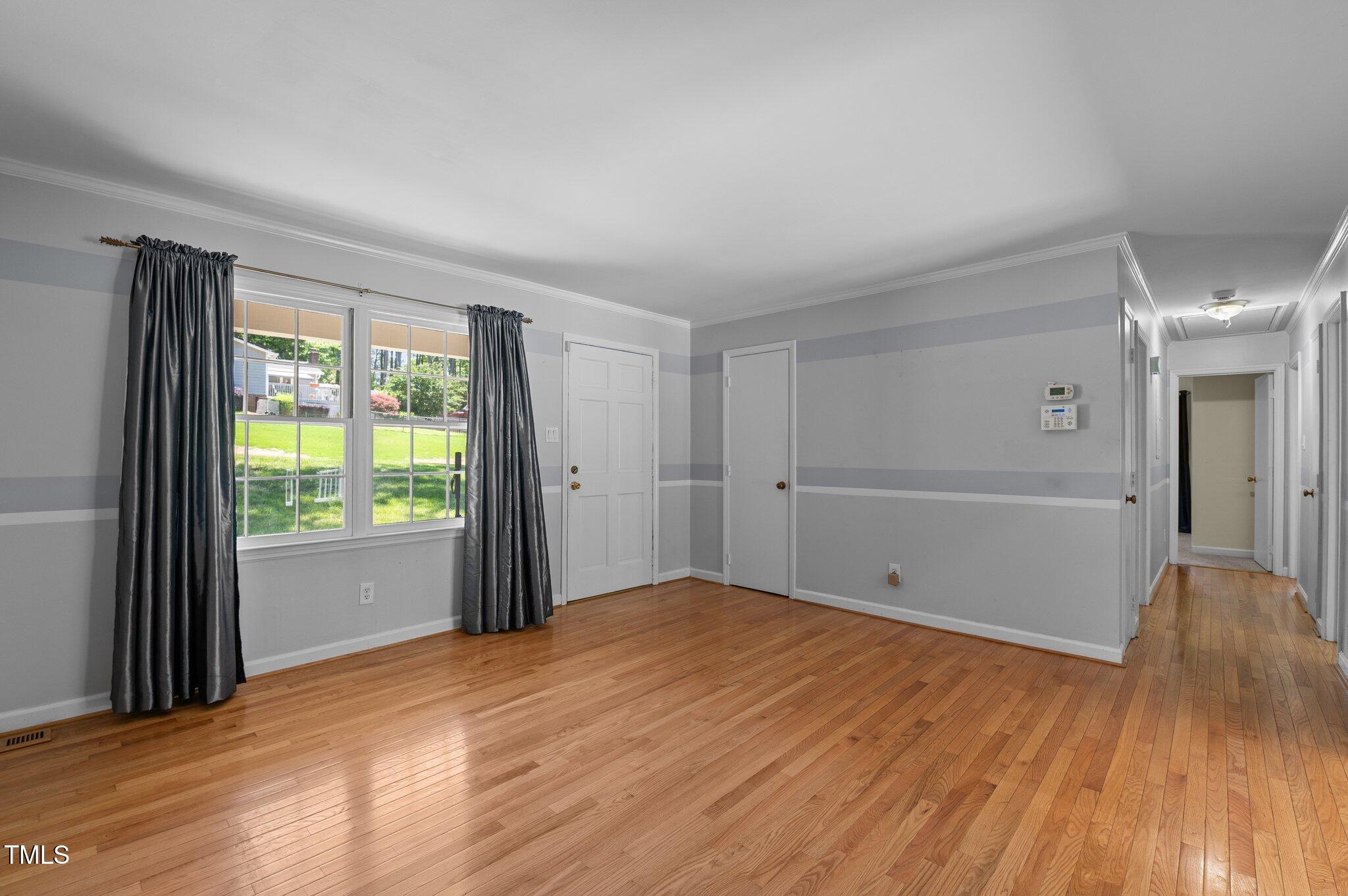 612 Harvest Lane Raleigh, NC 27606 - Photo 8 of 38 a view of an empty room with wooden floor and a window