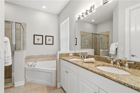 a bathroom with a granite countertop tub sink and mirror