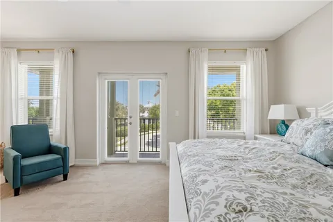 a bedroom with a bed and a couch with outer view