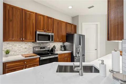 a kitchen with stainless steel appliances granite countertop a refrigerator and a stove top oven