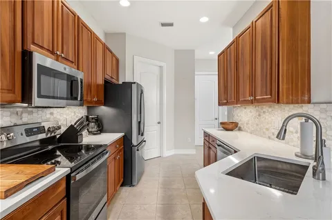 a kitchen with stainless steel appliances granite countertop a sink stove and refrigerator