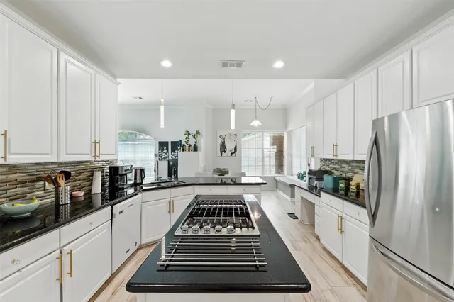 a large white kitchen with sink and refrigerator