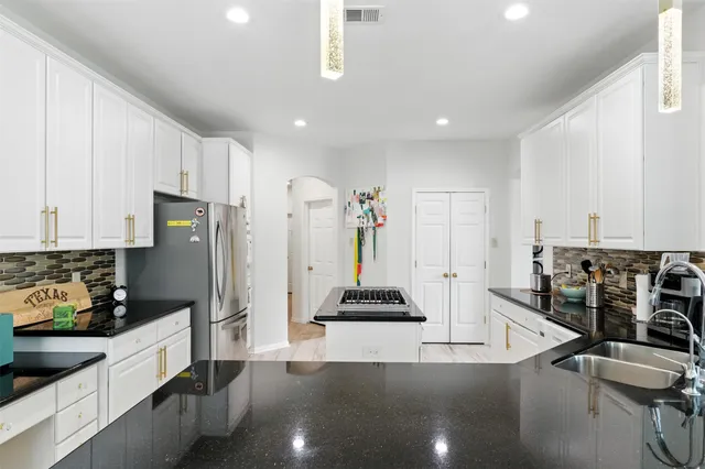 a kitchen with stainless steel appliances a refrigerator and a stove top oven