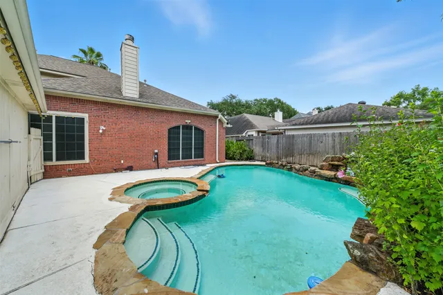 a swimming pool with outdoor seating and yard