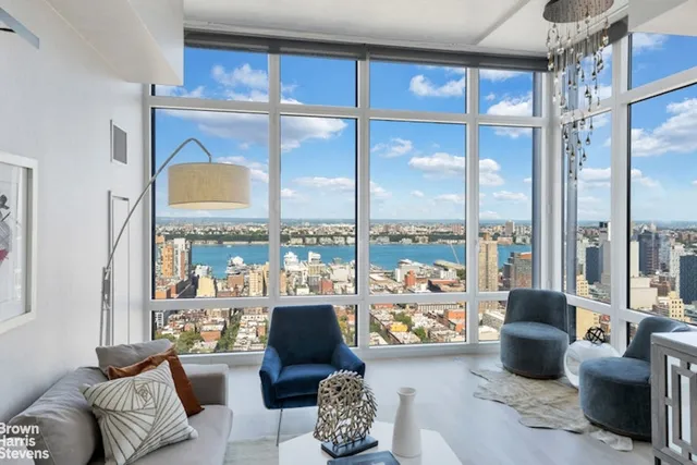 a living room with furniture and a floor to ceiling window