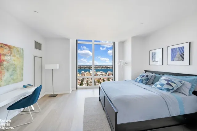 a bedroom with a bed and a large window