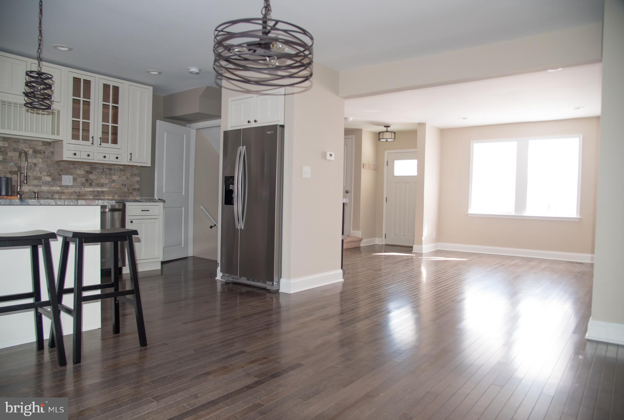 4130 Fairfax Road Baltimore, MD 21216 - Photo 2 of 30 a view of a hallway with wooden floor and a chandelier