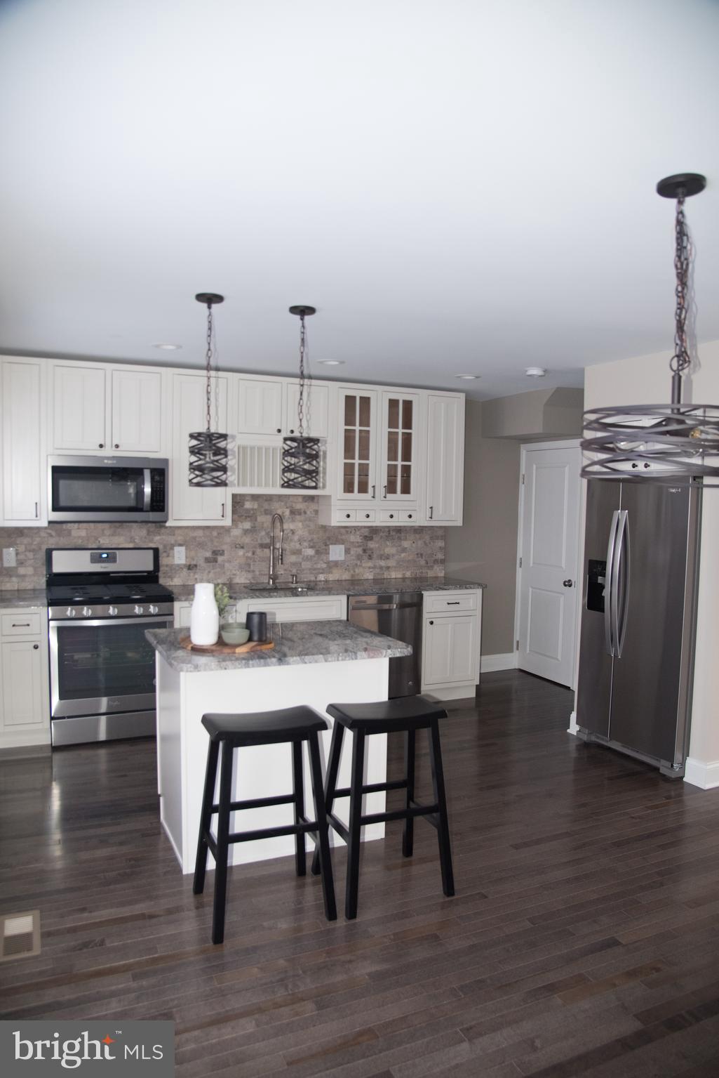 4130 Fairfax Road Baltimore, MD 21216 - Photo 6 of 30 a kitchen with kitchen island a stove a table and chairs in it