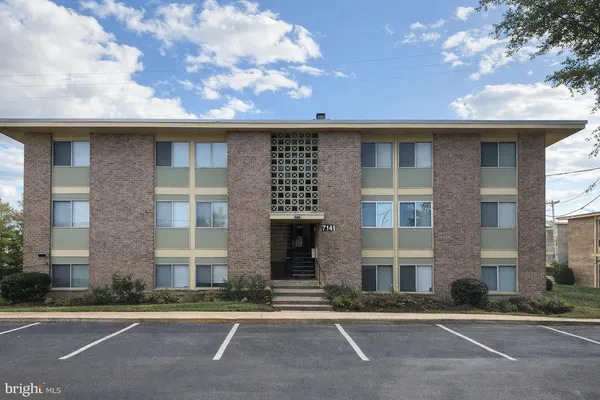 a front view of a residential apartment building with a yard
