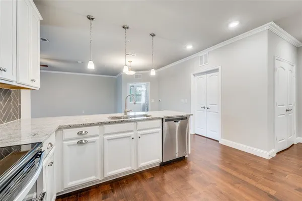 a kitchen with granite countertop white cabinets and stainless steel appliances