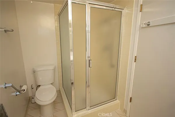 a bathroom with a granite countertop toilet and a shower
