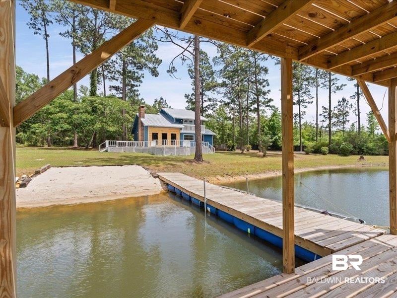 3160 Old Castleberry Road Brewton, AL 36426 - Photo 20 of 36 Wood-finish floating dock extending into the pond, with a sandy beach area