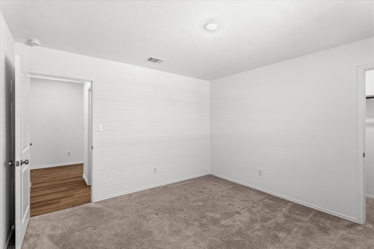 167 Jeffers Kyle, TX 78640 - Photo 18 of 40 Empty room featuring dark carpet and a smoke detector
