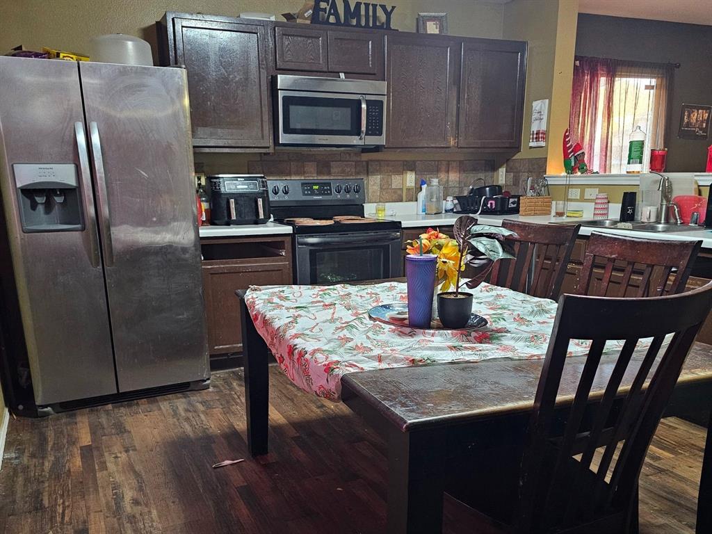 237 Cres Ridge Drive Fort Worth, TX 76140 - Photo 6 of 11 a kitchen with stainless steel appliances granite countertop a refrigerator a stove a sink a dining table and chairs