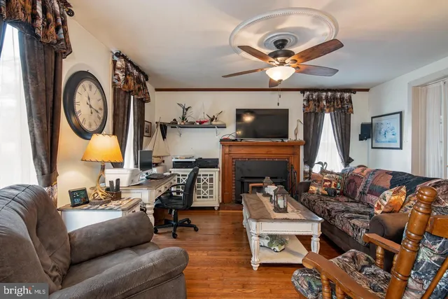a living room with furniture a fireplace and flat screen tv
