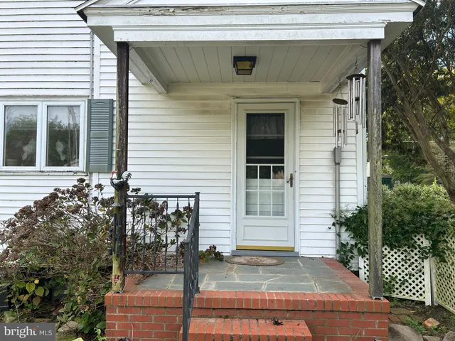 a front view of a house with a tree