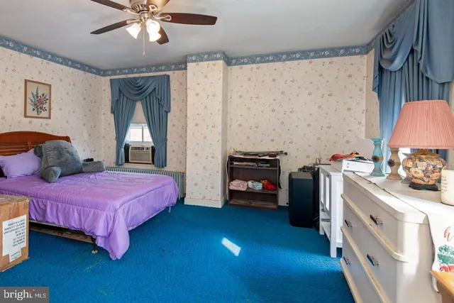 a bedroom with a bed dresser and a flat tv screen