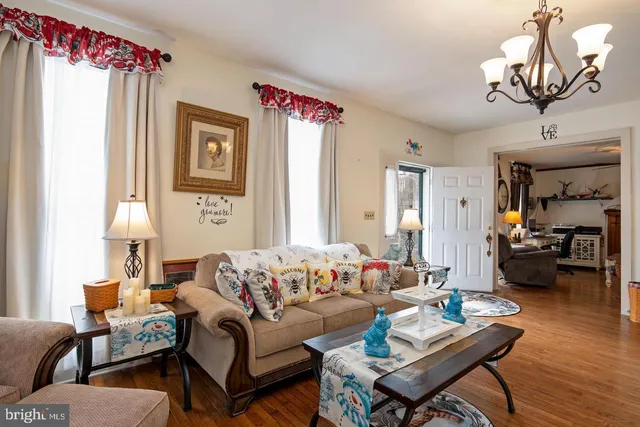 a living room with furniture a wooden floor and a chandelier