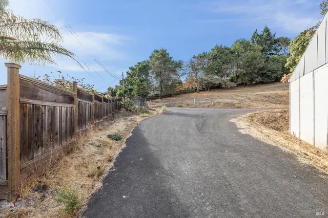 a view of a yard with wooden fence