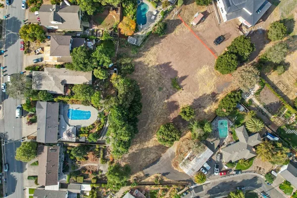 an aerial view of a house with a yard and large trees