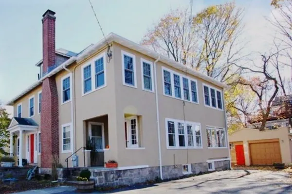 a front view of a house with a tree