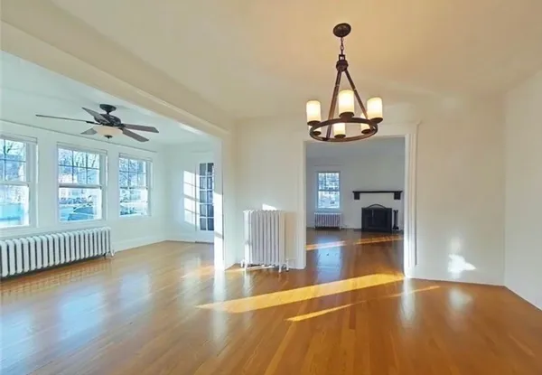 a view of a room with wooden floor portable chandelier and windows