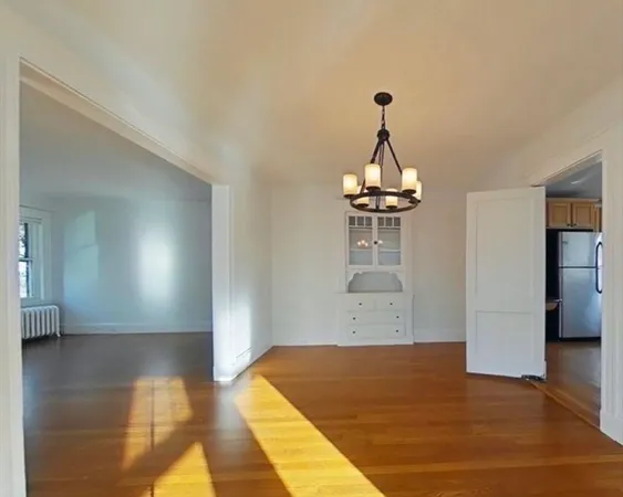 a view of a room with wooden floor and a ceiling fan
