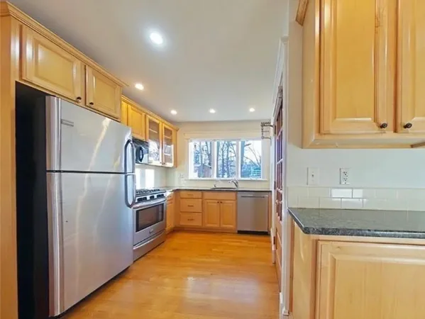 a kitchen with stainless steel appliances granite countertop a refrigerator a sink and a stove