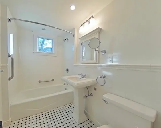 a bathroom with a sink toilet a mirror and shower