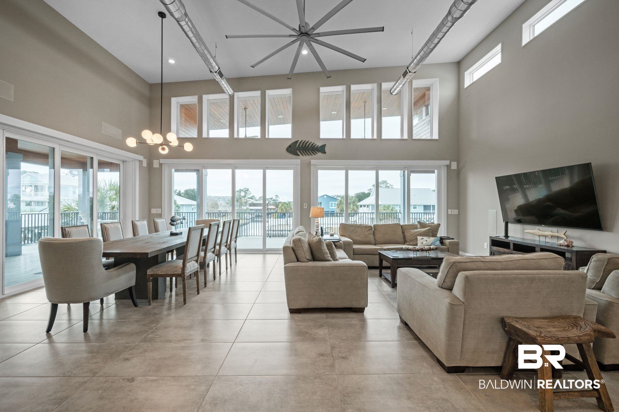 3840 Cotton Way Orange Beach, AL 36561 - Photo 3 of 75 Living room featuring a towering ceiling, plenty of natural light, and a notable chandelier
