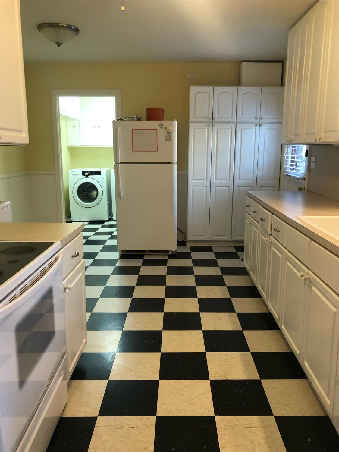2904 20th Street Lubbock, TX 79410 - Photo 15 of 35 a kitchen with a checkered floor and white cabinets