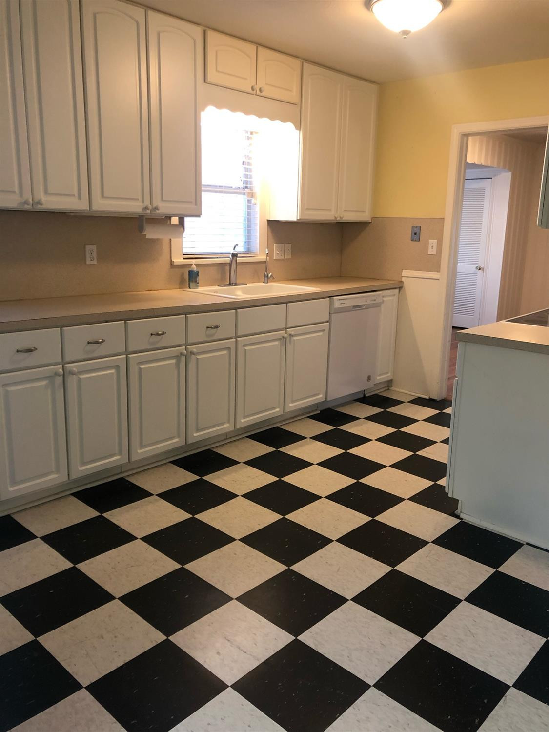 2904 20th Street Lubbock, TX 79410 - Photo 16 of 35 a kitchen with a checkered floor and white cabinets