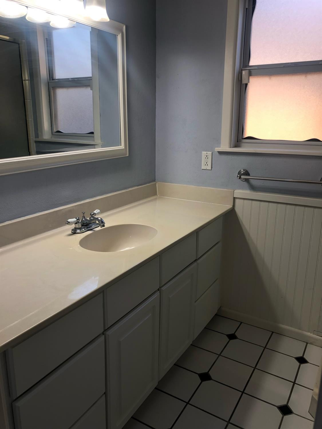 2904 20th Street Lubbock, TX 79410 - Photo 27 of 35 a bathroom with a sink vanity and mirror