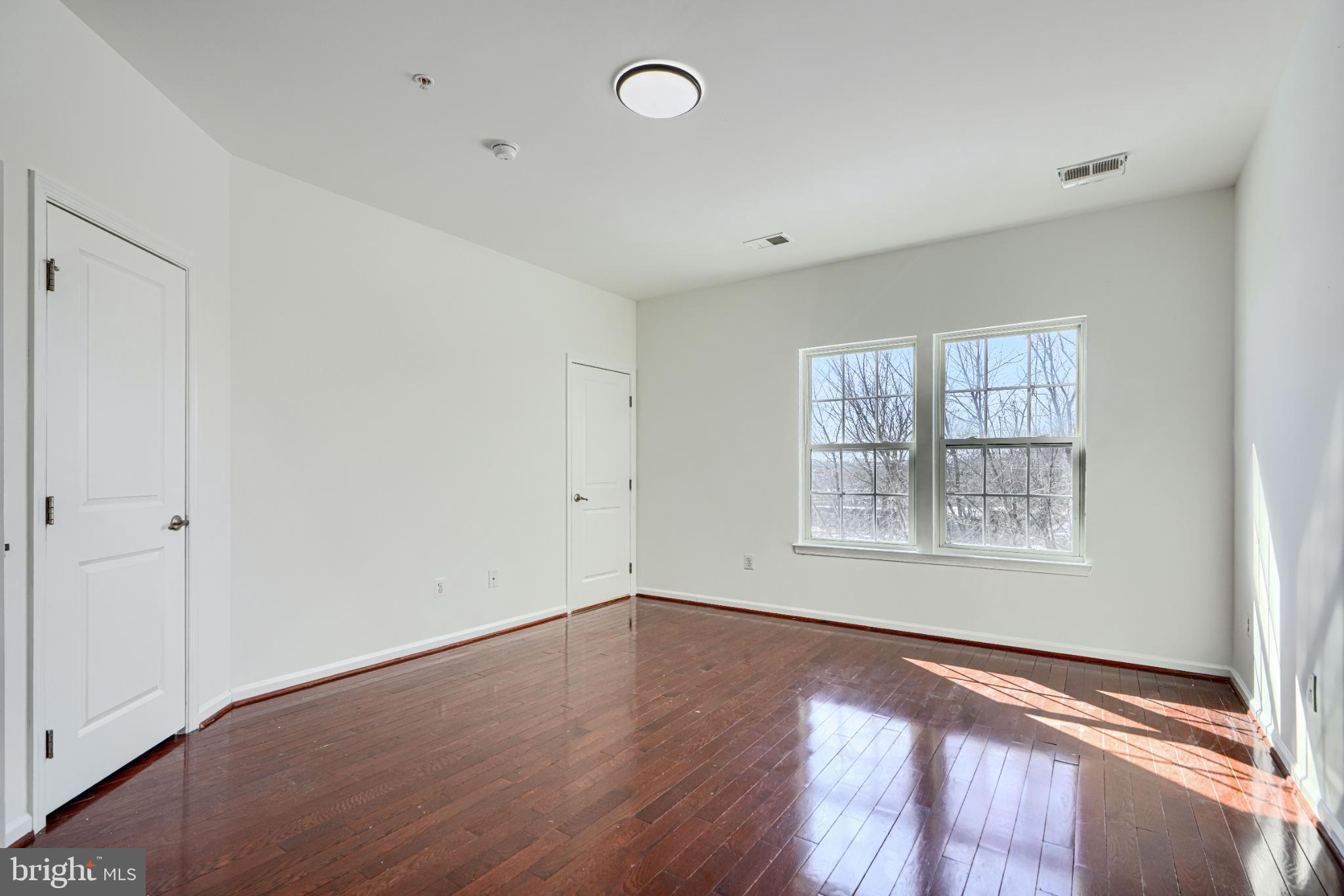7366 Matchbox Alley Elkridge, MD 21075 - Photo 20 of 32 a view of an empty room with wooden floor and a window