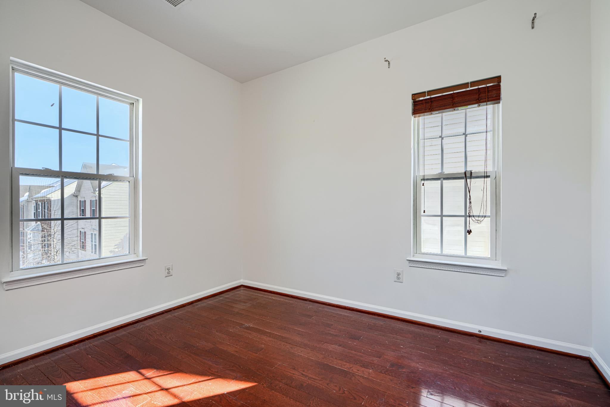 7366 Matchbox Alley Elkridge, MD 21075 - Photo 29 of 32 an empty room with wooden floor and windows