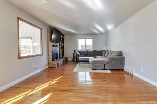 a living room with furniture and a wooden floor