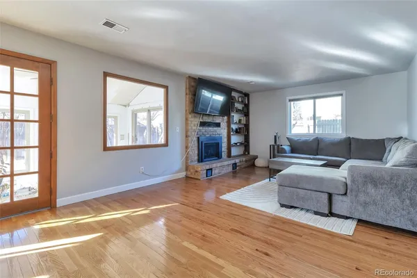 a living room with couches and a flat screen tv with wooden floor