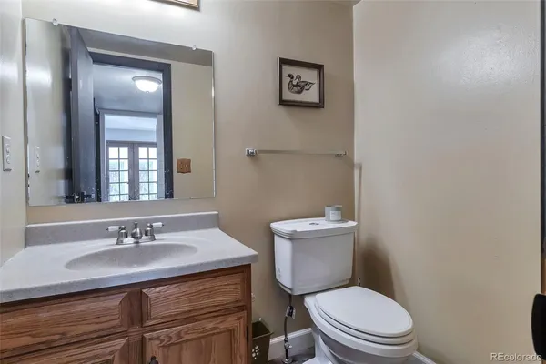 a bathroom with a granite countertop toilet sink and mirror