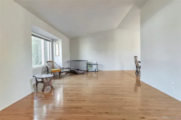 a view of a workspace with wooden floor and a window